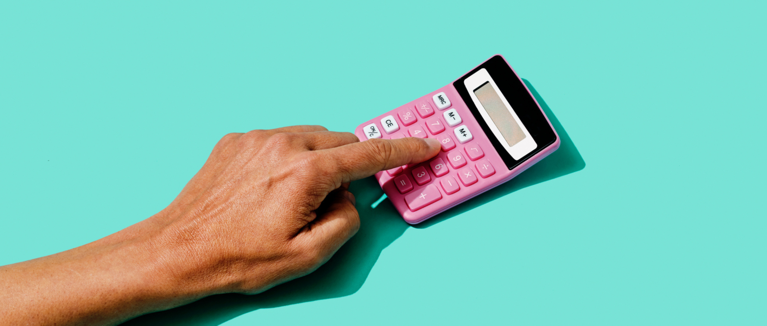 A person playing on a pink calculator.