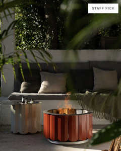 A designer, red smokeless fire outside on a patio.