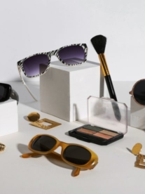 Sunglasses, jewellery and accessories laid out on a table.