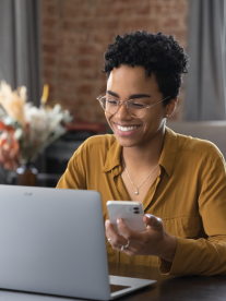 A young african woman with glasses on sitting at her Acer computer on a teams or zoom meeting.