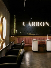 A hairsalon with a neon light that says carbon