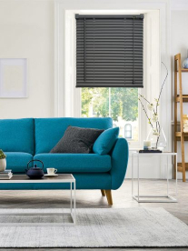 A modernist teal couch with a Scandinavian look in a white lounge.