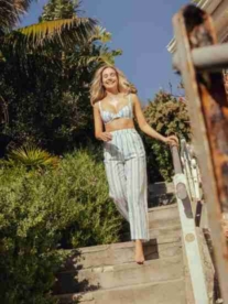 A pretty blonde girl walking down stairs in summer.