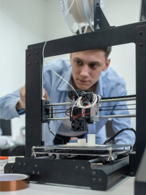 A man working on a 3D machine.