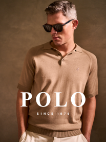 man with brown shirt, white pants and hands in pocket