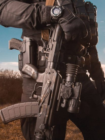 Advance Tactical person holding an automatic weapon outdoors