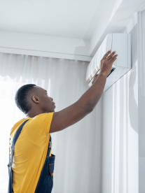 A man instaling an airconditioning unit in a home
