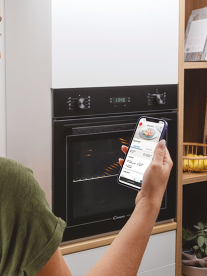 A person looking at a cooking timer app on their phone in the kitchen.