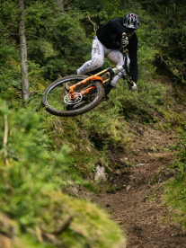 A man on a mountain bike doing a big jump on a Commensal bike.