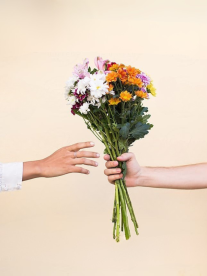 A man handing a woman flowers.