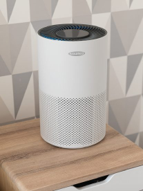 A white Solenco humidifier sitting on a wooden bedside table.