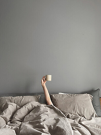 Person in bed with coffee cup