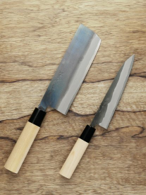 Kitchen Samurai knifes with bone handle on a wooden chopping board