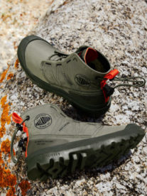 A pair of olive green palladium boots on a rock