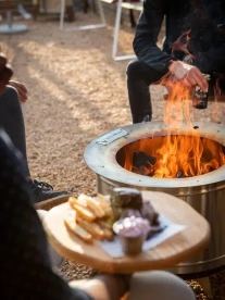 A couple enjoying a smokeless fire pit outdoors