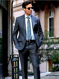 man in grey suit with hands in pocket