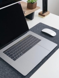 A macbook on a desktop with a magic mouse