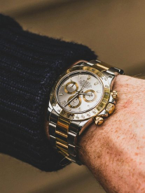 A mean wearing a silver and gold rolex watch.