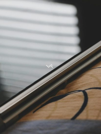 A black HP laptop sitting on a wooden table