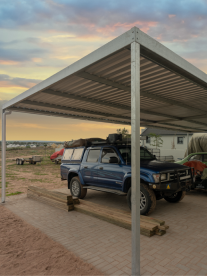 Blue 4x4 parked under a steel carport